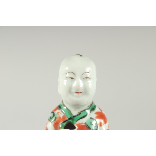 95 - A CHINESE COPPER RED AND GREEN PORCELAIN FIGURE, 11.5cm high.