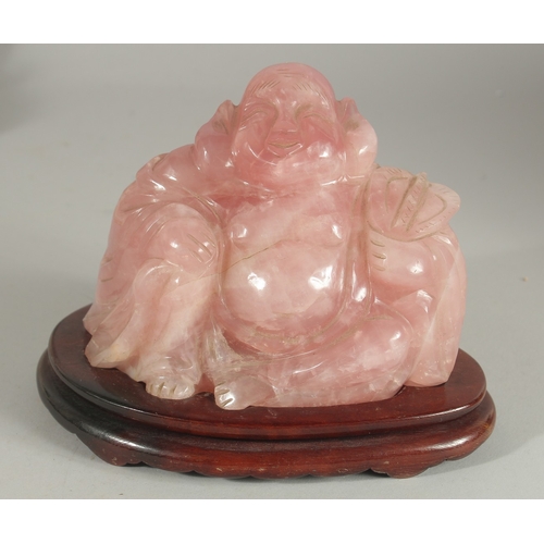 99 - A CHINESE CARVED ROSE QUARTZ BUDDHA on wooden stand, 19cm wide overall.