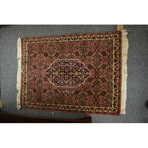 256 - A good small Persian rug with all-over floral decoration 83cm x 63cm.