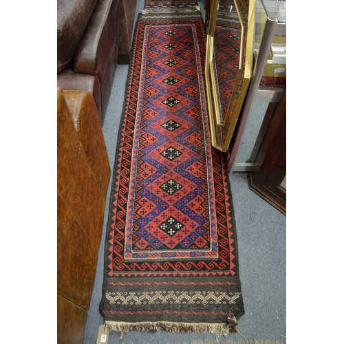 280 - A Persian runner, red and blue ground with stylised cross shaped decoration 290cm x 68cm.