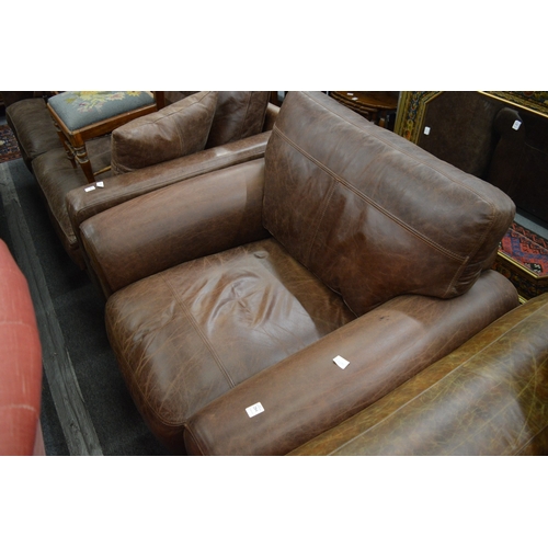 284 - A brown leather upholstered armchair.