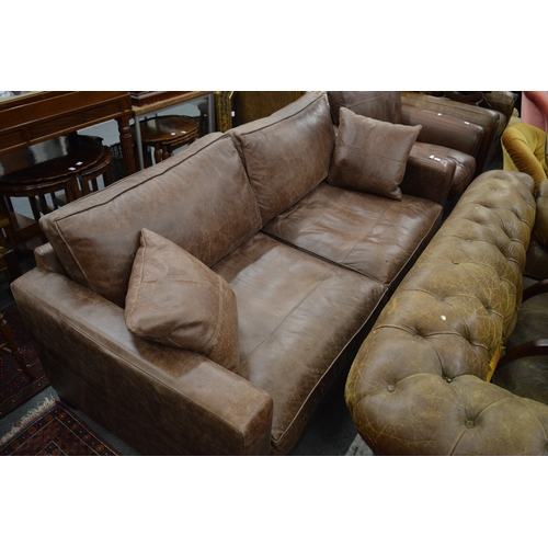 285 - A brown leather upholstered large two seater settee.