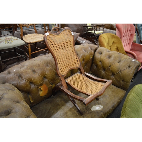 288 - An Edwardian mahogany folding chair with cane work back panel and seats.