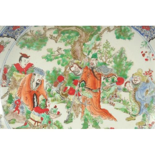 102 - A LARGE CHINESE FAMILLE VERTE PORCELAIN CHARGER, painted with figures around a tree, 45cdm diameter.