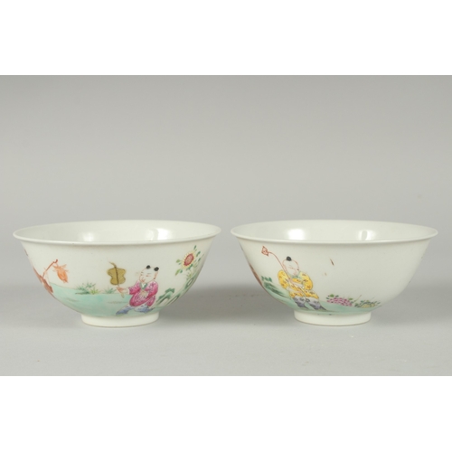 103 - A PAIR OF EARLY 20TH CENTURY FAMILLE ROSE PORCELAIN RICE BOWLS, painted with boys, each with red cha... 