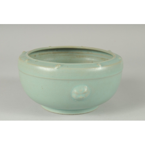 105 - A CHINESE CELADON GLAZE PORCELAIN BOWL, the sides with moulded handles and rim with raised bosses, 1... 