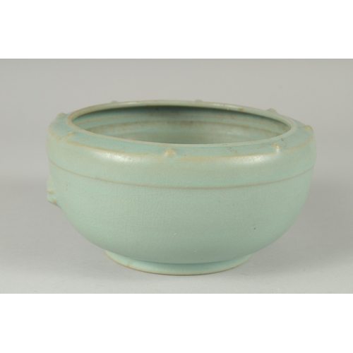 105 - A CHINESE CELADON GLAZE PORCELAIN BOWL, the sides with moulded handles and rim with raised bosses, 1... 