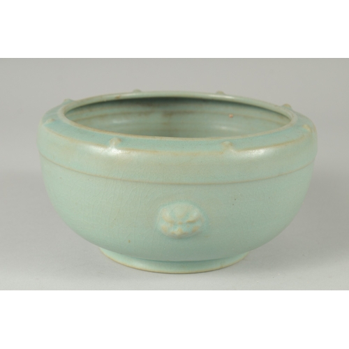 105 - A CHINESE CELADON GLAZE PORCELAIN BOWL, the sides with moulded handles and rim with raised bosses, 1... 