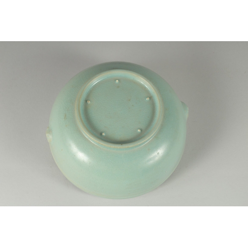 105 - A CHINESE CELADON GLAZE PORCELAIN BOWL, the sides with moulded handles and rim with raised bosses, 1... 