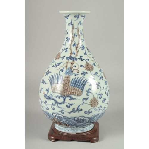 107 - A CHINESE UNDERGLAZE RED, BLUE AND WHITE DRAGON AND PHOENIX YUHUCHUNPING VASE, on a fitted hardwood ... 