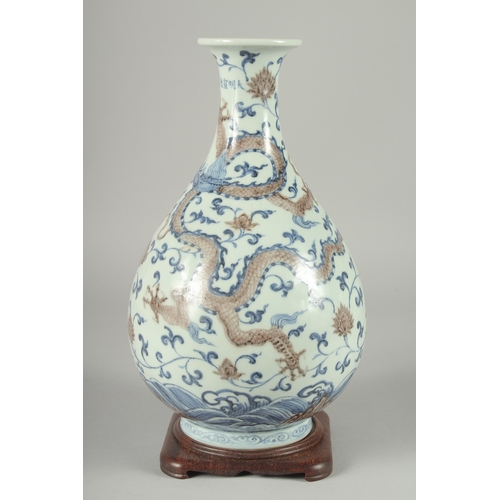 107 - A CHINESE UNDERGLAZE RED, BLUE AND WHITE DRAGON AND PHOENIX YUHUCHUNPING VASE, on a fitted hardwood ... 