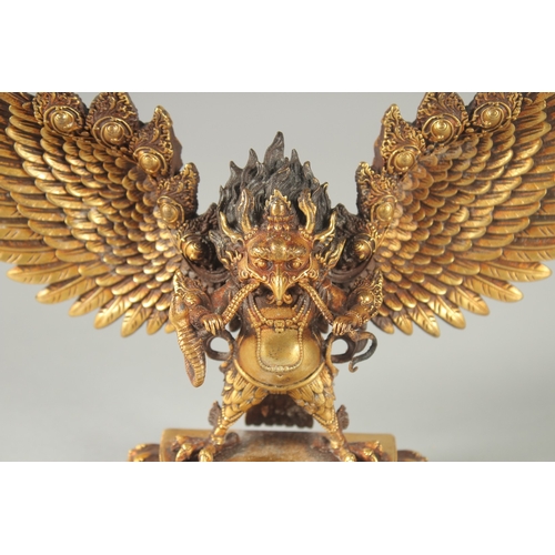 125 - A FINE TIBETAN GILT BRONZE DEITY, with wings outstretched, inscribed to the base, 19cm wide.