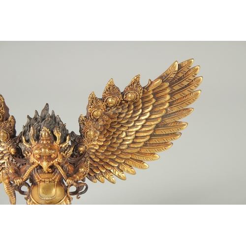 125 - A FINE TIBETAN GILT BRONZE DEITY, with wings outstretched, inscribed to the base, 19cm wide.