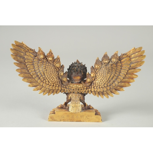 125 - A FINE TIBETAN GILT BRONZE DEITY, with wings outstretched, inscribed to the base, 19cm wide.