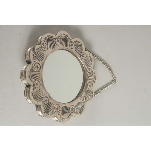 129 - A SMALL EMBOSSED SILVER MIRROR, 10cm wide.