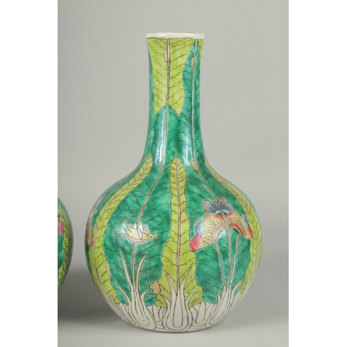 137 - A PAIR OF CHINESE FAMILLE VERTE PORCELAIN BOTTLE VASES, painted with butterflies and leaves, 35cm hi... 