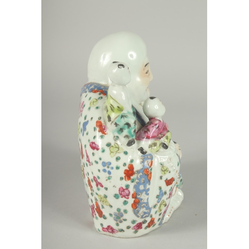 139 - A CHINESE FAMILLE ROSE PORCELAIN BUDDHA, with five children upon him, 19.5cm high.