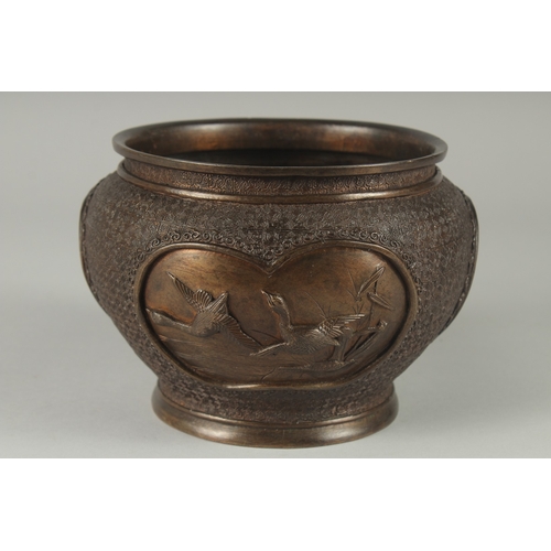 140 - A JAPANESE BRONZE JARDINIERE, with relief panels of birds, 19cm diameter.