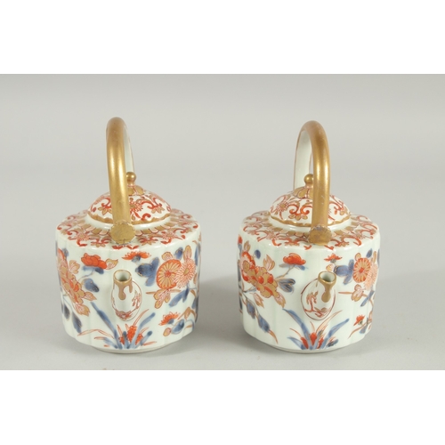 145 - A FINE PAIR OF JAPANESE IMARI PORCELAIN TEAPOTS, painted in the typical Imari palette with blue, red... 