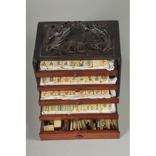 153 - A GOOD 19TH CENTURY CHINESE MAHJONG GAME SET IN A CARVED HARDWOOD BOX, with carved bone counters, 22... 