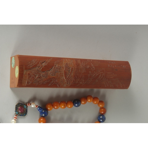 154 - A CHINESE CARVED BAMBOO BOX CONTAINING A BEADED NECKLACE, together with a carved bamboo wrist rest, ... 