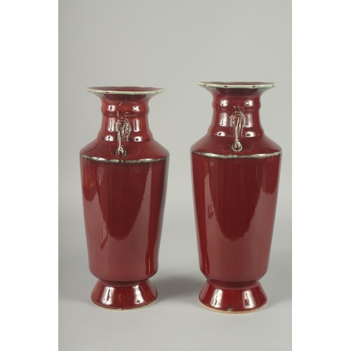 156 - A PAIR OF CHINESE SANG DE BOEUF TWIN HANDLE VASES, (one with minor rim repair), 34cm high (slightly ... 