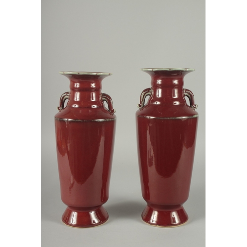 156 - A PAIR OF CHINESE SANG DE BOEUF TWIN HANDLE VASES, (one with minor rim repair), 34cm high (slightly ... 