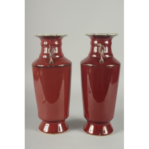 156 - A PAIR OF CHINESE SANG DE BOEUF TWIN HANDLE VASES, (one with minor rim repair), 34cm high (slightly ... 