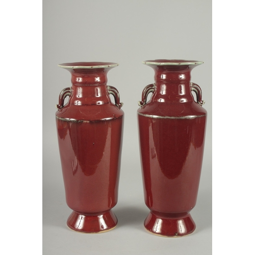 156 - A PAIR OF CHINESE SANG DE BOEUF TWIN HANDLE VASES, (one with minor rim repair), 34cm high (slightly ... 