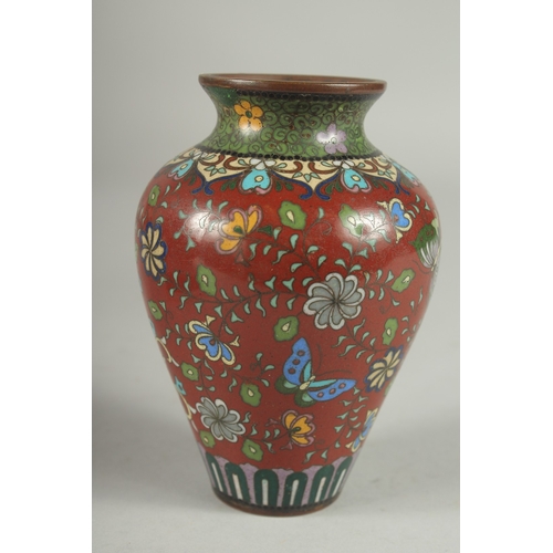 168 - A CHINESE RED GROUND CLOISONNE PHOENIX VASE, with butterflies and various floral motifs, 12.5cm high... 