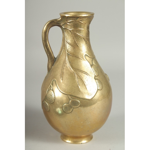 180 - A JAPANESE BRASS JUG, with relief foliate decoration, 23cm high.