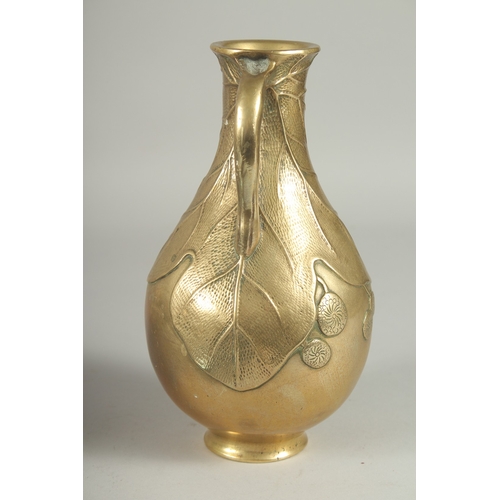 180 - A JAPANESE BRASS JUG, with relief foliate decoration, 23cm high.