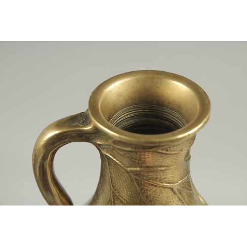 180 - A JAPANESE BRASS JUG, with relief foliate decoration, 23cm high.