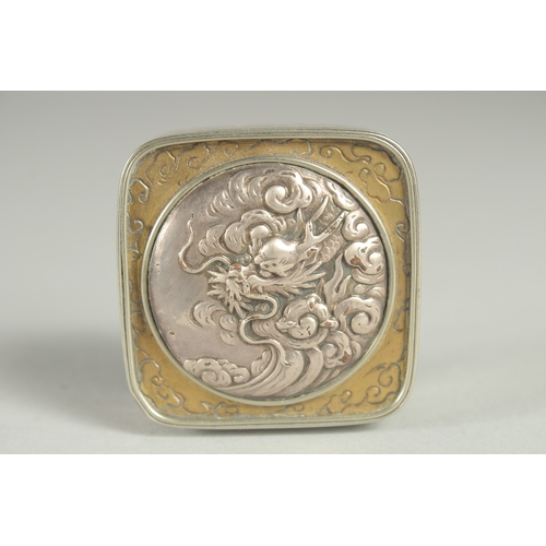 181 - A SMALL SIGNED JAPANESE WHITE METAL AND BRASS BOX, the hinged lid with relief dragon roundel, 5cm sq... 