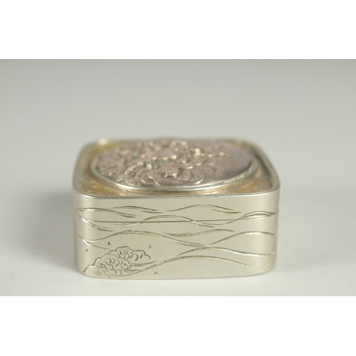 181 - A SMALL SIGNED JAPANESE WHITE METAL AND BRASS BOX, the hinged lid with relief dragon roundel, 5cm sq... 