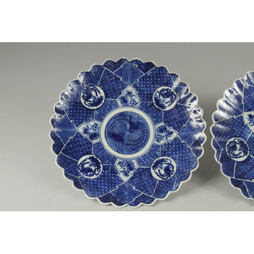 193 - A PAIR OF JAPANESE BLUE AND WHITE PORCELAIN PETAL-FORM PLATES, 31cm wide.