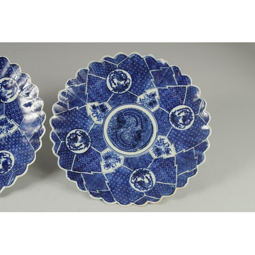 193 - A PAIR OF JAPANESE BLUE AND WHITE PORCELAIN PETAL-FORM PLATES, 31cm wide.