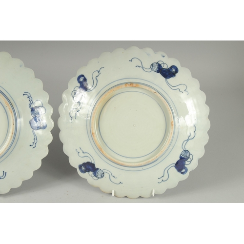 193 - A PAIR OF JAPANESE BLUE AND WHITE PORCELAIN PETAL-FORM PLATES, 31cm wide.