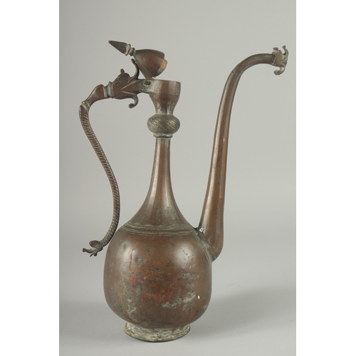 219 - AN 18TH CENTURY PERSIAN SAFAVID COPPER EWER, the handle and spout with dragon head terminals, 38cm h... 