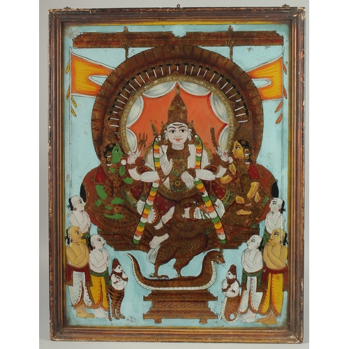 232 - A VERY FINE AND LARGE SOUTH INDIAN TANJORE REVERSE GLASS PAINTING OF A DEITY, inset within a wooden ... 