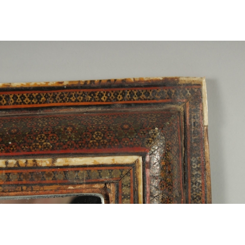 238 - A 19TH CENTURY QAJAR KHATAMKARI INLAID WOODEN MIRROR, comprised of bone plates and a fine network of... 