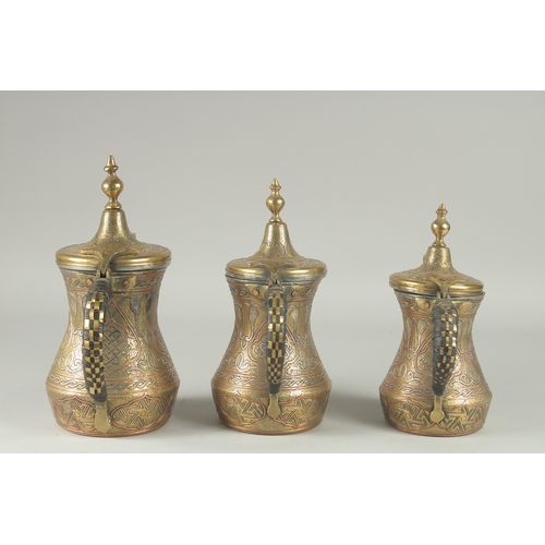 250 - THREE EYGPTIAN CAIROWARE SILVER AND COPPER INLAID BRASS COFFEE POTS, of graduating sizes, each inscr... 