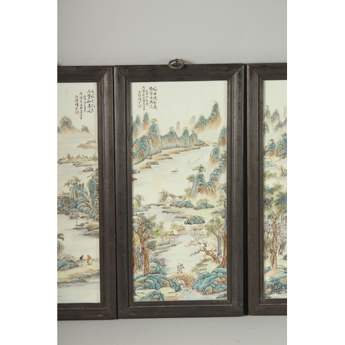 40 - FOUR CHINESE FAMILLE VERTE PORCELAIN PANELS, inset within wooden frames, each depicting mountainous ... 