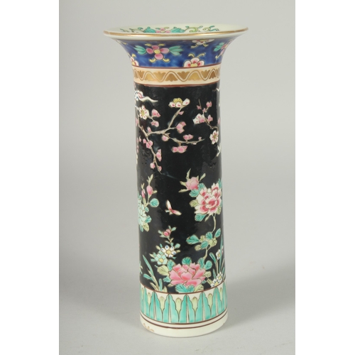 44 - A FAMILLE NOIR PORCELAIN CYLINDRICAL VASE, painted with peacocks and flora, mark to base, 26cm high.