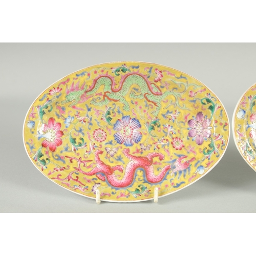 51 - A PAIR OF CHINESE YELLOW GROUND FAMILLE ROSE PORCELAIN OVAL DISHES, painted with dragon and flora, e... 