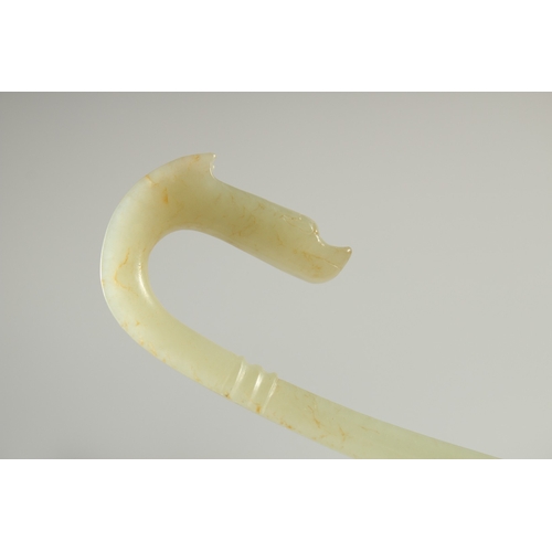 580 - A LONG CARVED JADE BELT HOOK, with dragon head, 25.5cm long.