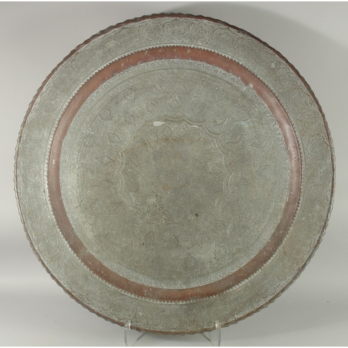 605 - A VERY LARGE ISLAMIC ENGRAVED TINNED COPPER TRAY, 78cm diameter.