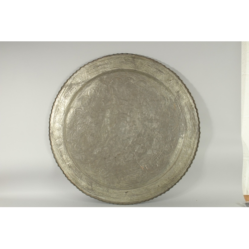 606 - A VERY LARGE ISLAMIC ENGRAVED TINNED COPPER TRAY, with raised engraved decoration depicting animals ... 