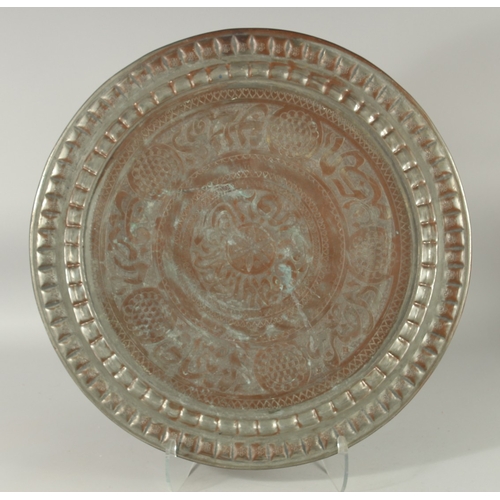 607 - AN ISLAMIC ENGRAVED TINNED COPPER DISH, with bands of calligraphy, 56cm diameter.