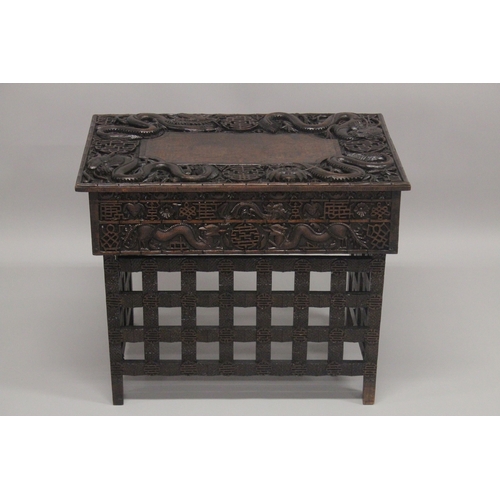 609 - AN EARLY 20TH CENTURY CHINESE HARDWOOD FOLDING DESK / TABLE, with two small drawers and folding leg ... 